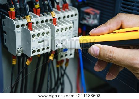Checking voltage in switchboard with a detector. Electrical background