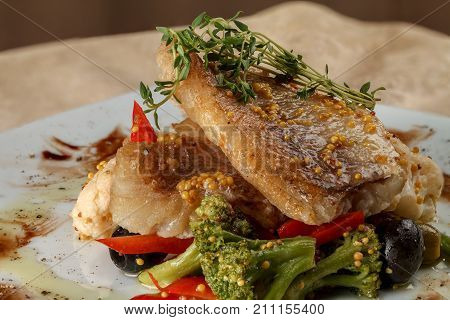 Fried white fish fillets with cauliflower and broccoli with pepper and olives and beans