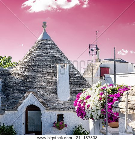 Typical Trullo of Alberobello with rose sky background
