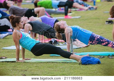ATLANTA, GA - JULY 2017: Dozens of people do the reverse plank pose as they take part in a free group yoga class at the Old Fourth Ward Park in Atlanta GA on July 2 2017.