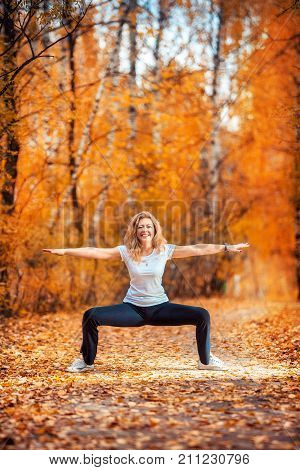 Beautiful Woman Doing Yoga Outdoors In Autumn