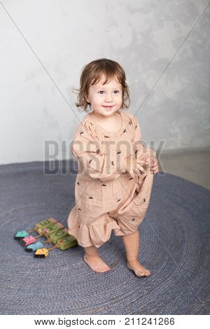 Little happy girl playing with toy on floor. Kindergarten.