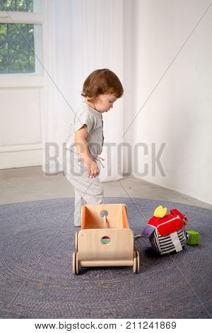 Little happy girl playing with toy on floor. Kindergarten.
