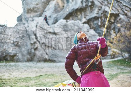 woman belayer with the rope looking outside of camera