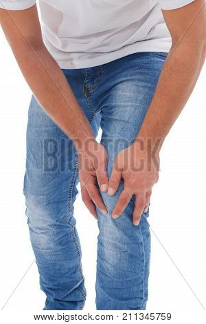 A man in jeans and a white T-shirt is holding onto his leg. On a white background.