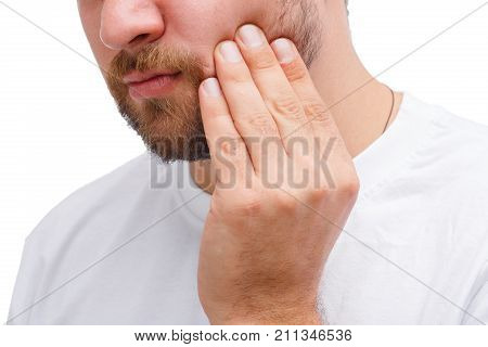 A man in a white T-shirt is holding on to a sick tooth. On a white background.