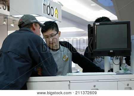 Burnaby, BC, Canada - April 03, 2017 : People asking fido sales clerk about cellphone plan inside Burnaby shopping mall