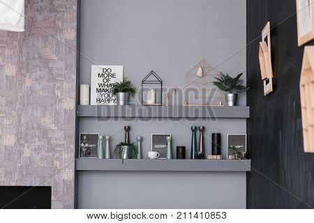 contemporary scandinavian interior with shelves full of decor objects on the grey wall.