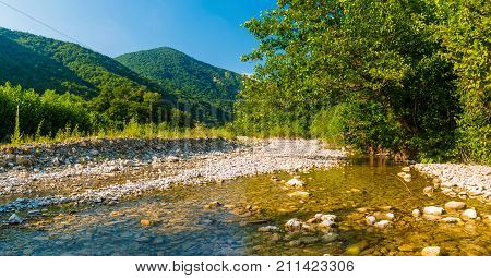 Panoramic view of Makopse river flowing in ravine on the background of Tamyurdepe mountain in the light of the setting sun Sochi Russia