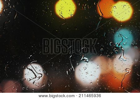 Raindrops On A Car Window With Beautifully Blurred Background Of Street Traffic Lights