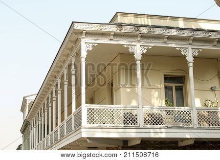 A nostalgic and listed balcony or oriel with carved ornaments. Solid sky background