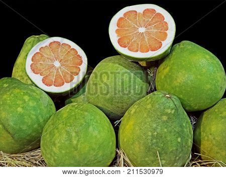 Pile of Pomelo with Slice Isolated on Black Background