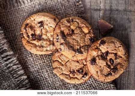 Chocolate cookies on dark napkin on wooden table. Closeup of a group of assorted cookies.
