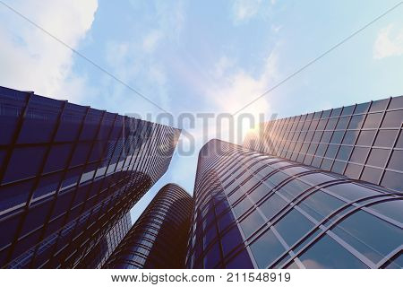 Low angle view of skyscrapers. Skyscrapers at sunset looking up perspective. Bottom view of modern skyscrapers in business district in evening light at sunset. Business concept of success industry tech architecture. 3D rendering