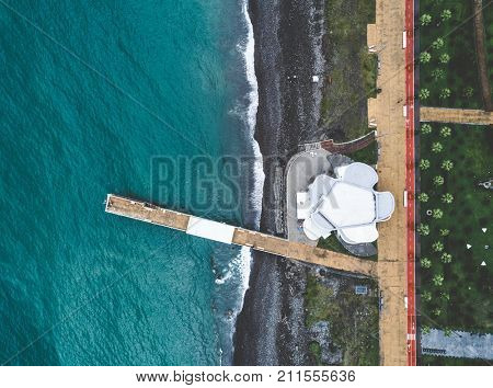 Aerial view of desrted embankment with modern building, banquette and greeen park. Batumi, Georgia. Top view.