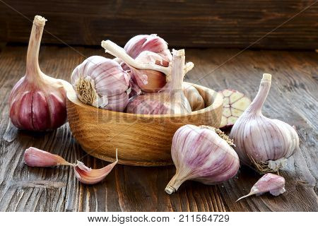 Garlic in a wooden bowl on the kitchen table