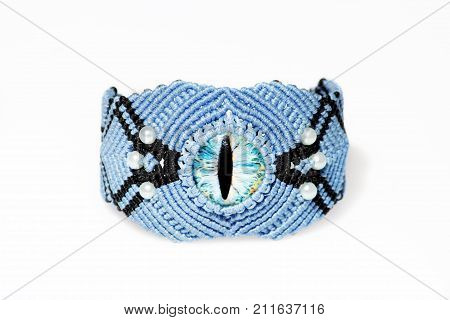 blue bracelet for the hand from waxed thread and blue dragon eye in the technique of macrame on a white background.
