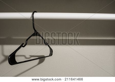 Single black coathanger on a closet rod