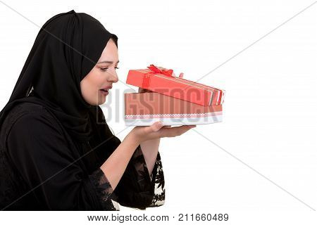 Happy young muslim woman with shopping bag and gift boxes isolated over white background.