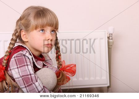 히터 근처에 앉아 슬픈 소녀입니다. 어린이 우울증.