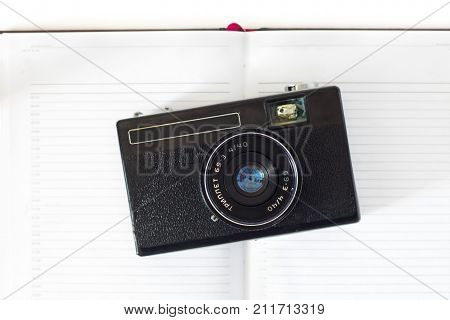 Retro Still Camera And Some Old Photos On White Background .
