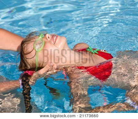 Instructor girl learn child swim in swimming pool.