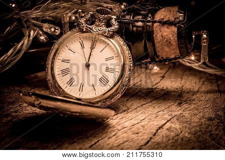 New Year Eve Celebration Background With Antique Coloc And Champagne Bottle On Rustic Wood