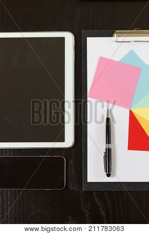 clipboard mobile phone tablet on black wooden table ready for business
