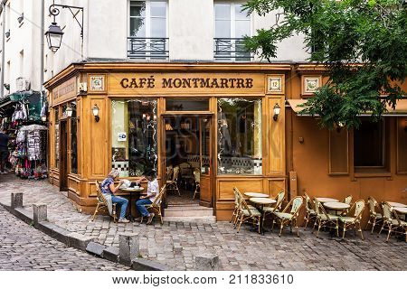 Paris France - July 06 2017: The charming Cafe Montmartre on Montmartre hill. Senior couple sitting at table and drinking coffee. Montmartre with traditional french cafes and art galleries is one of the most visited landmarks in Paris.