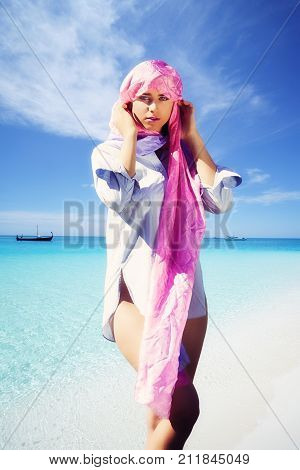 Young woman on the beach with headscarf.