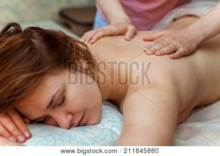 Beautiful young girl having massage in spa salon