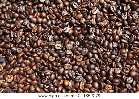 black fragrant fried coffee beans on the table, texture