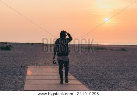 Men walking on the beach on sunset