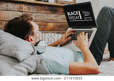 Man using a laptop to buy in a Black Friday shopping special web