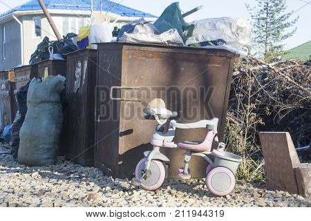 tricycle discarded to cesspool. concept of a bygone childhood