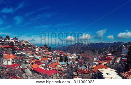 Pedoulas Village On Cyprus In Troodos Mountains With Blue Sky And Copy Space. Panoramic View.