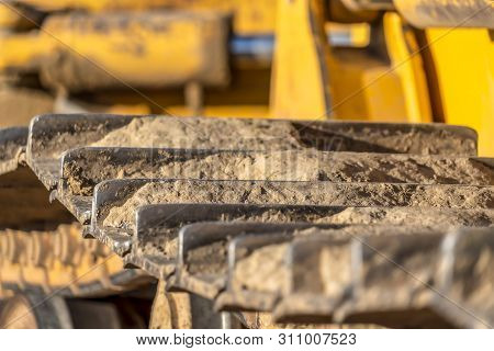 Metal Grouser Pad Close Up Of A Yellow Construction Vehicle On A Sunny Day.