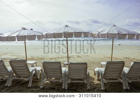 Landscape View Of Sea Beach In The Morning, Beach Umbellas And Bench On Seaside With Green Tree, Sum