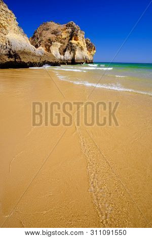 Beach Alvor Poente With Beautiful Water Color And Cliffs. Vacation In Algarve, Portugal.