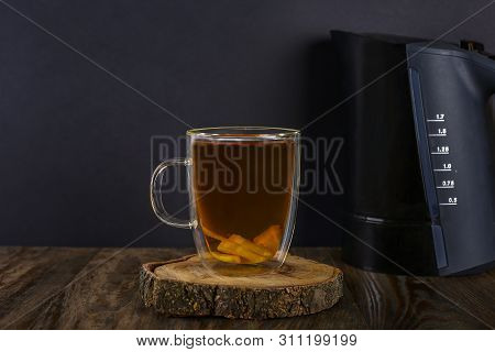 Black Tea With Lemon In Double Bottom Cup. Black Teapot On Wooden Table.