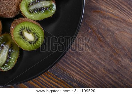 Kiwi On A Black Plate. Top View