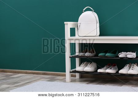 Shoe Rack With Different Footwear Near Color Wall, Space For Text. Stylish Hallway Interior