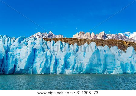 Scenic View Of Blue Ice Of Glacier Grey, The Ripple Of Lke Grey And The Beautiful Snow Mountain At T