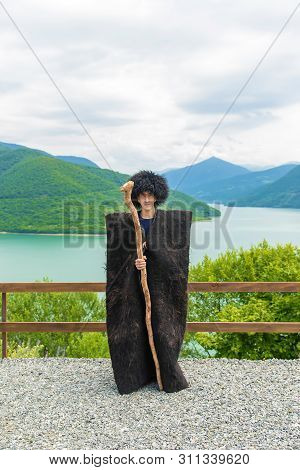 Georgian Man In A Beech Costume On A Background Of Mountains. Selective Focus.