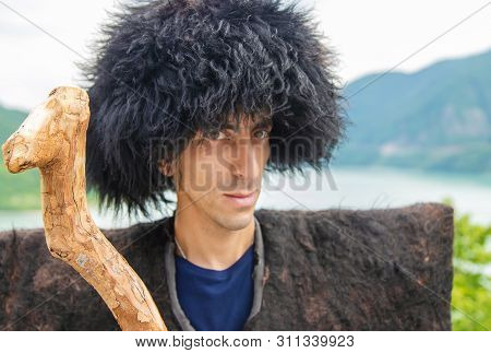 Georgian Man In A Beech Costume On A Background Of Mountains. Selective Focus.
