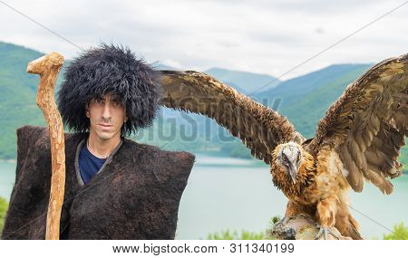 Georgian Man In A Beech Costume On A Background Of Mountains. Selective Focus.