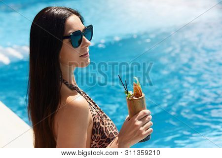 Tenned Beautiful Woman In Leopard Print Swimming Suit And Black Sunlasses Sitting In Swimming Poolsi