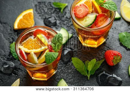Refreshing Pimms Cocktail With Fruit And Vegetables On Rustic Black Table