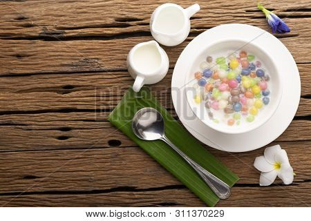 Thai Sweets And Colorful Ball Flour In A White Spoon On A Banana Leaf, Coconut On An Old Wooden Tabl