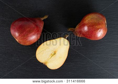 Group Of Two Whole One Half Of Fresh Dark Red Pear Anjou Flatlay On Grey Stone